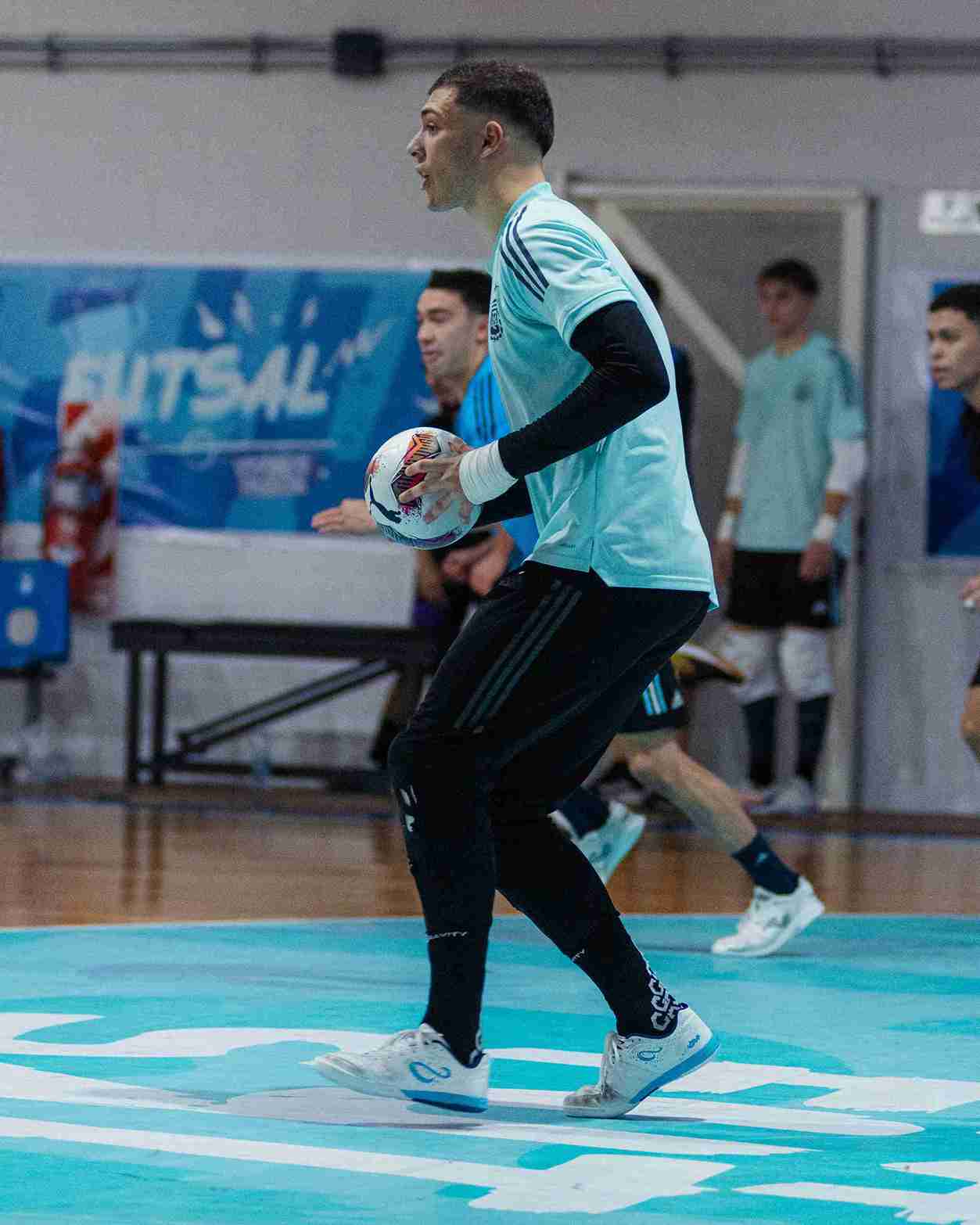 Futsal player in action with a ball on a futsal court