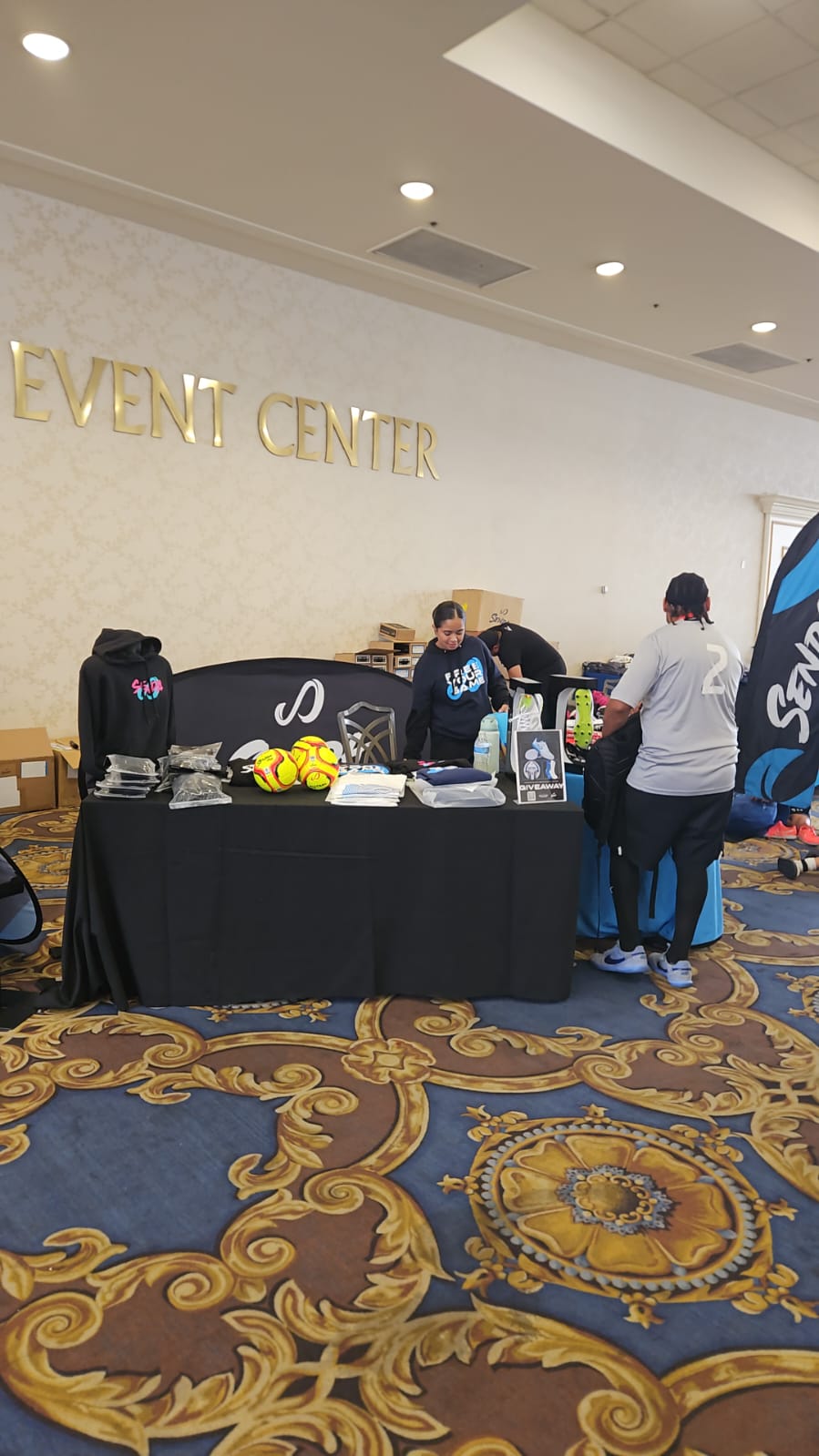 Futsal event center with people around a stand with futsal gear on it in Las Vegas.