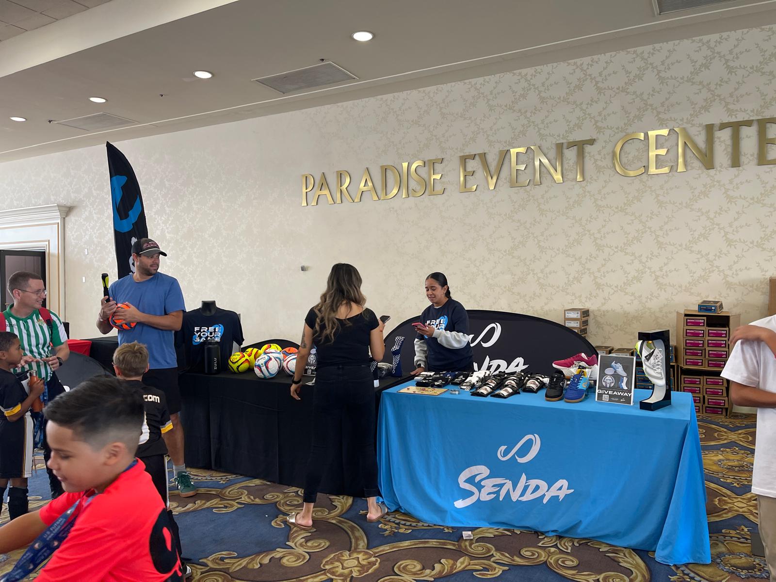 Futsal Event setup at Paradise Event Center with people around tables displaying branded items in Las Vegas.