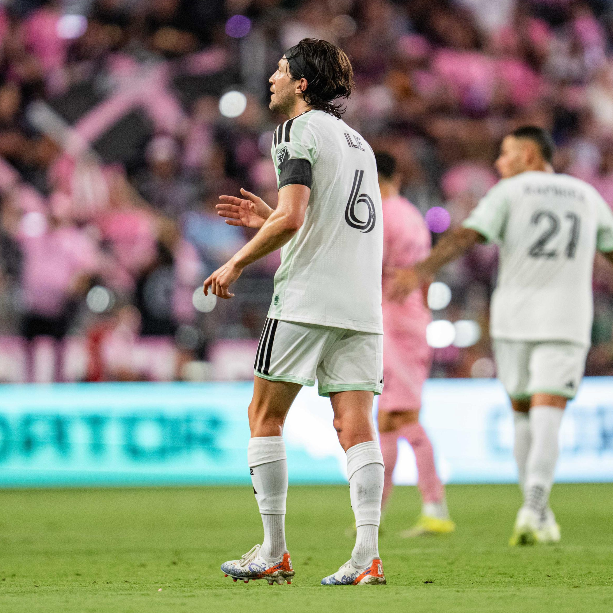 Soccer player in a white jersey with number 6 on a field during a match.