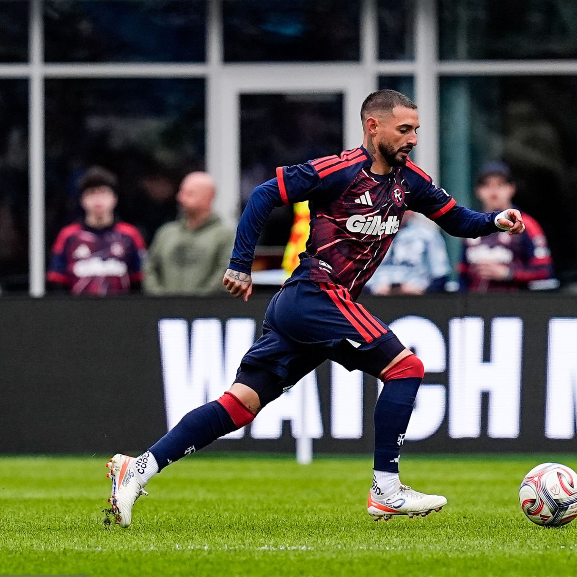 Soccer player in action on a field with spectators in the background