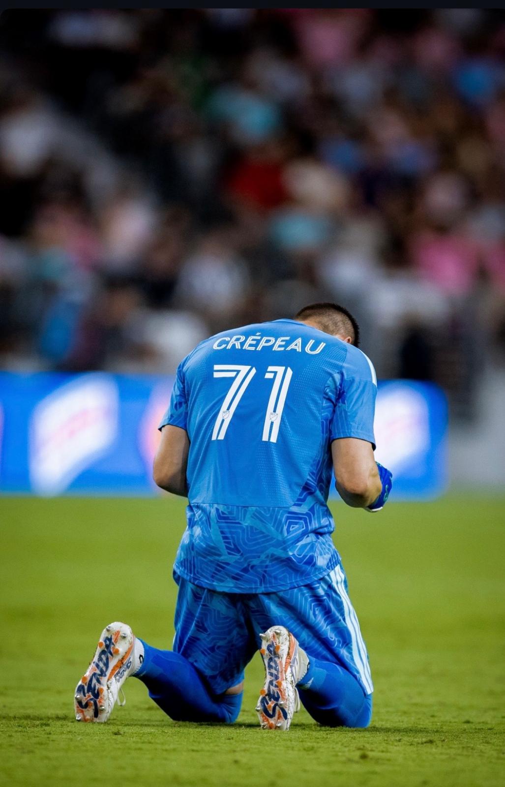 Soccer player in blue jersey with 'CREÚpeau 71' on the back, kneeling on a soccer field.