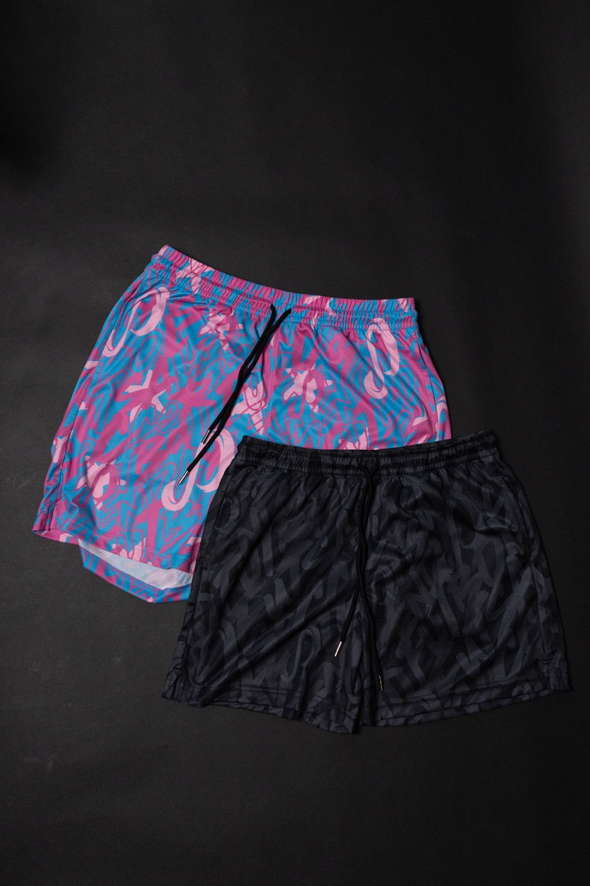 Two pairs of shorts, one pink and blue patterned and one black, on a black background. Senda Lifestyle Apparel Collection