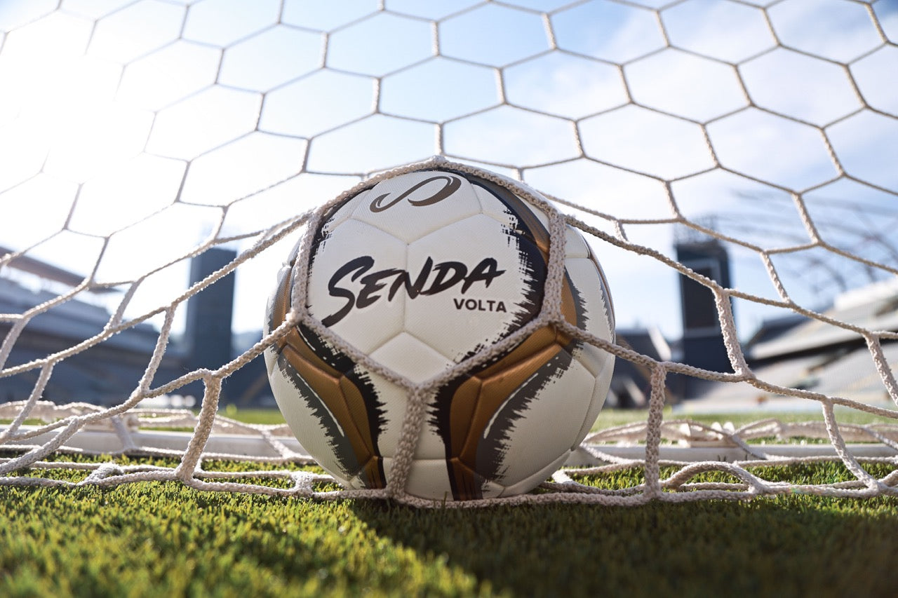 Senda Volta soccer ball in a goal with a blurred stadium background