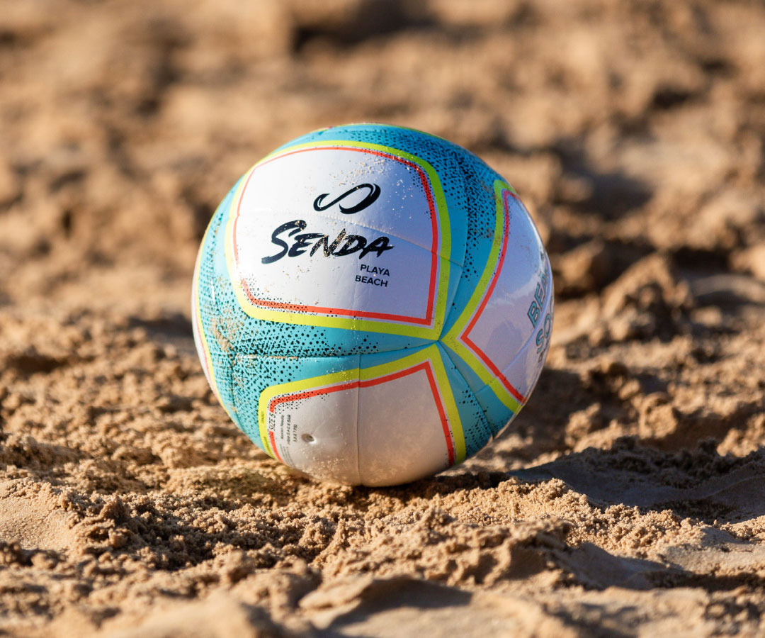 Colorful beach soccer ball with 'Senda' branding on a sandy surface