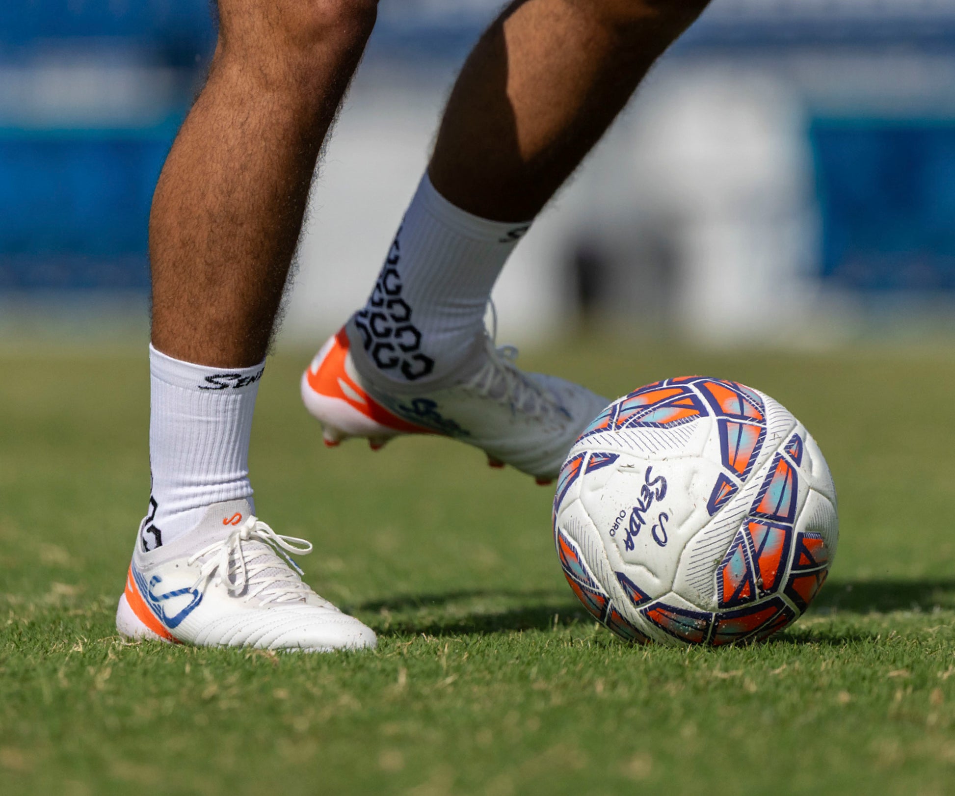 Person kicking a soccer ball on a grass field