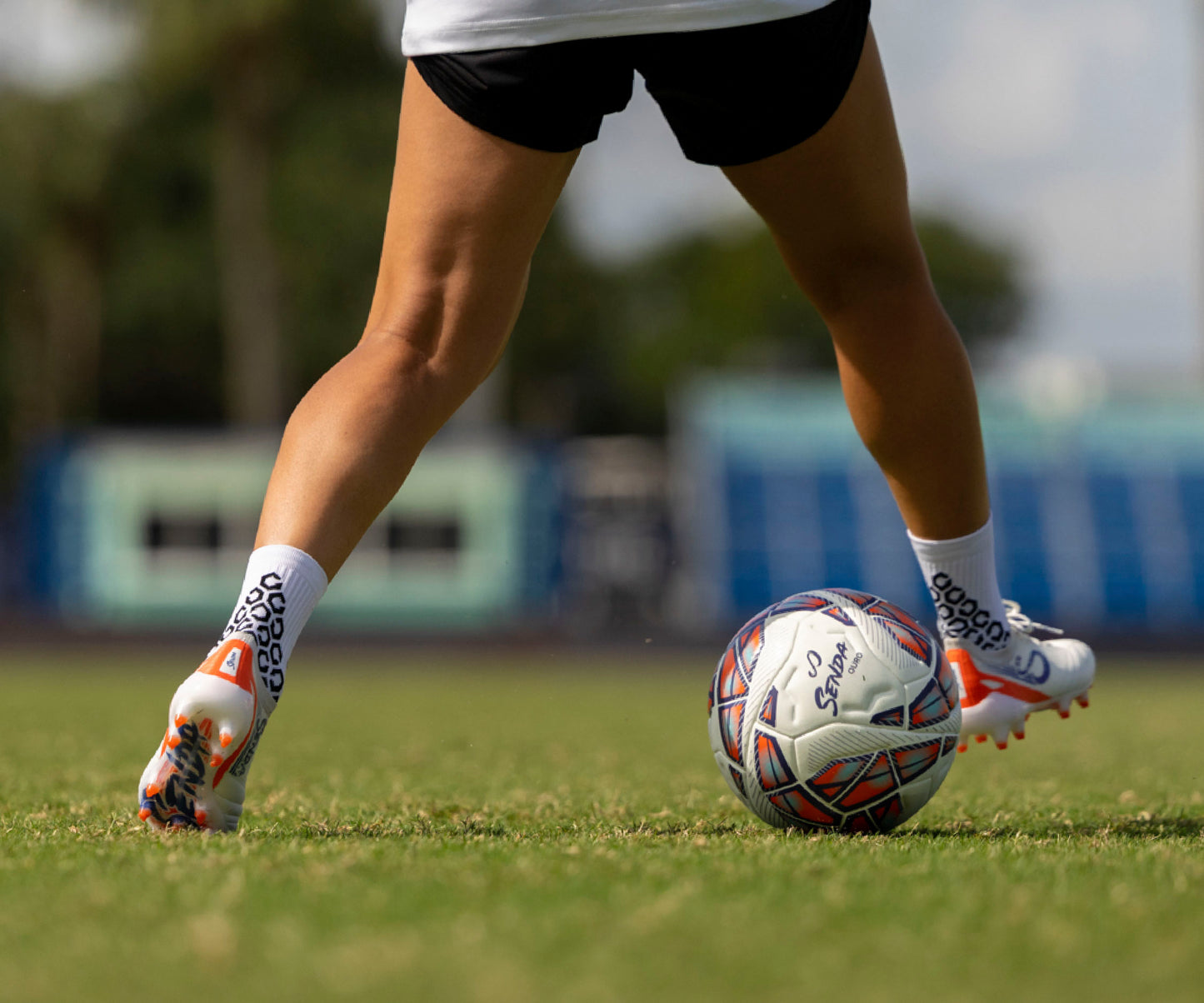 Person playing soccer on a grass field with a blurred background