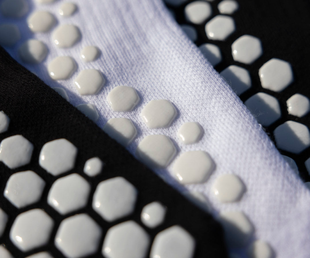 Close-up of white textured fabric with hexagonal patterns on a black background