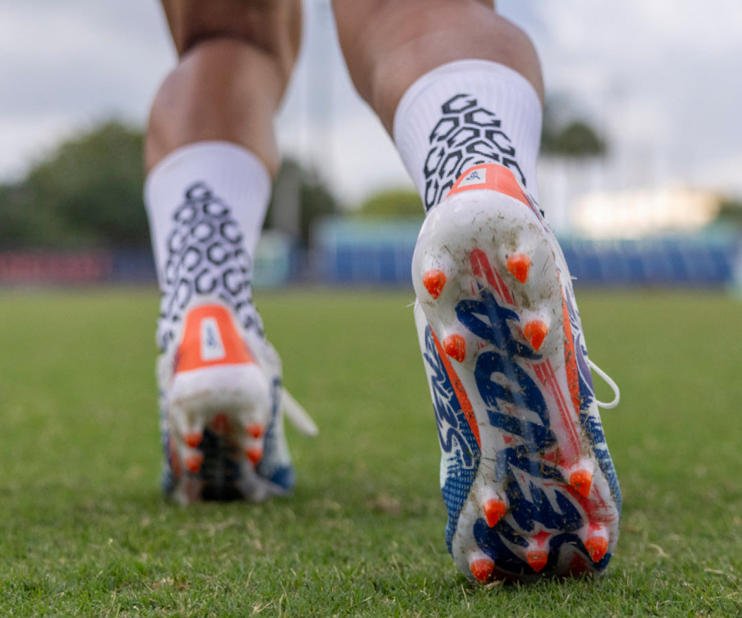 Close-up of Senda sole soccer cleats on a grass field
