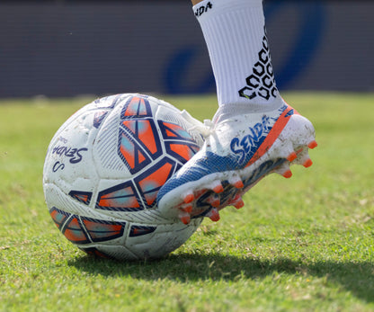Senda Soccer shoe kicking a soccer ball on grass