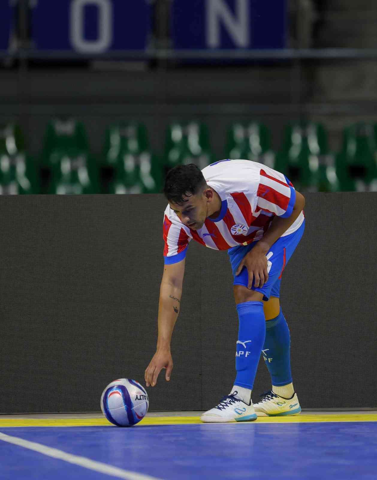 Person in a sports uniform interacting with a ball on a court