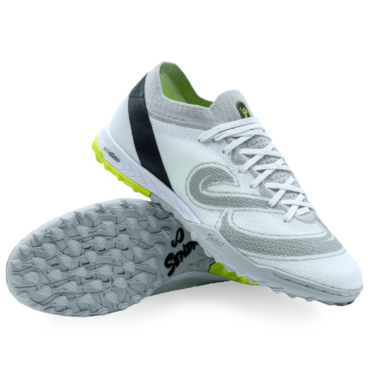 White turf shoe with black and green accents on a white background