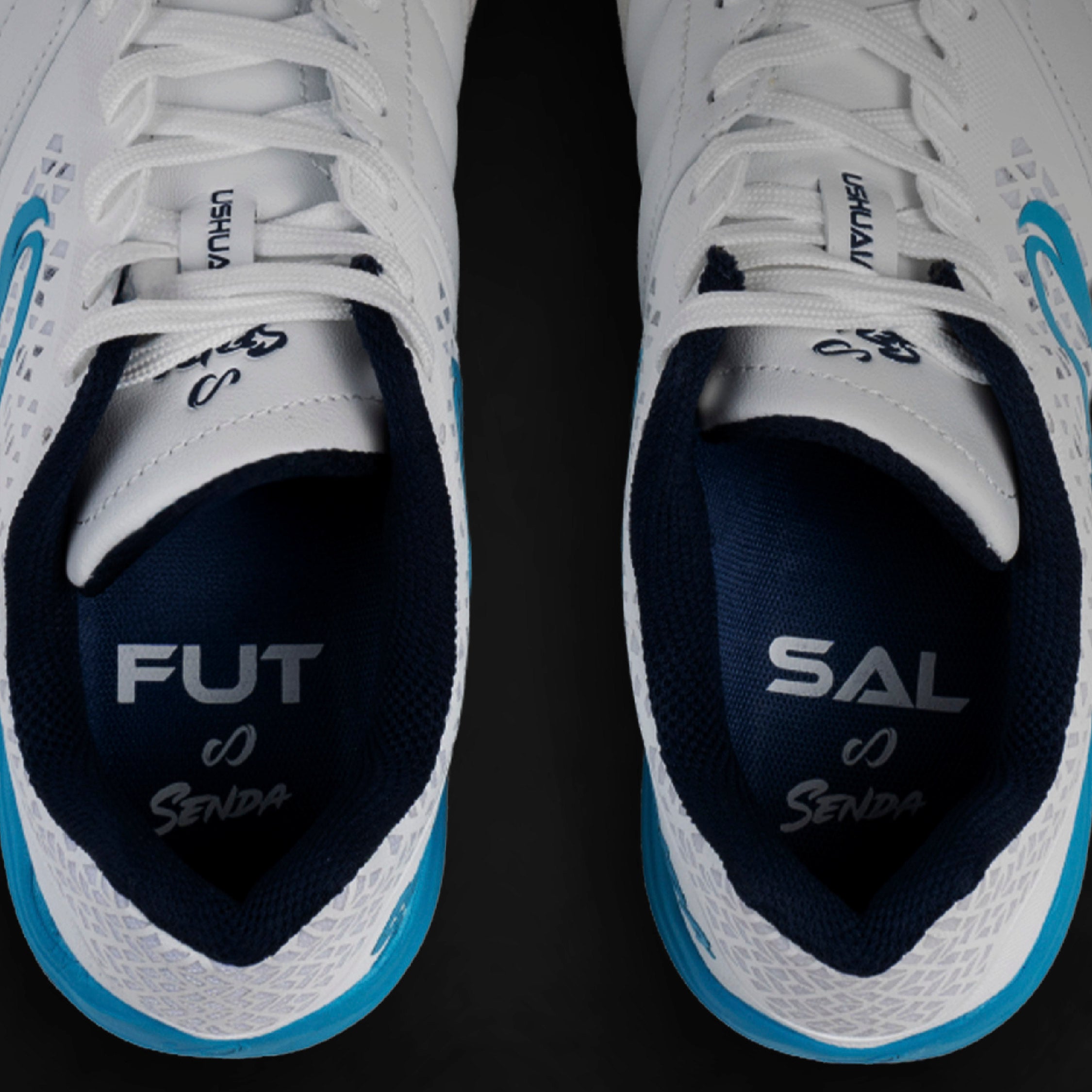 White sports insole futsal shoes with blue accents on a black background