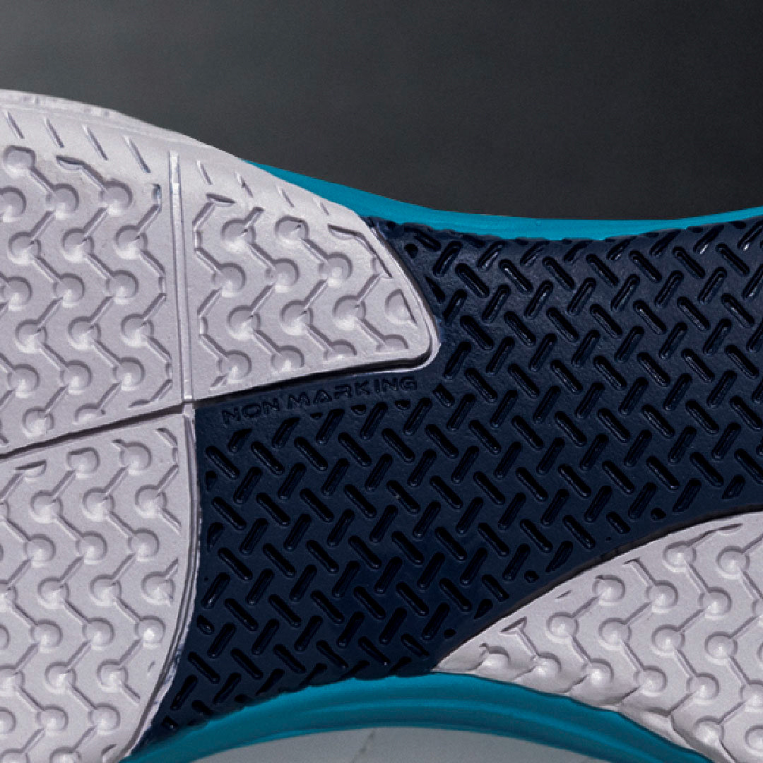 Close-up of a futsal shoe sole with textured pattern and "non marking" sole on a dark background