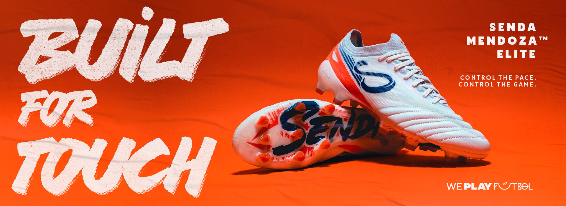 White sports Senda cleats with orange and blue accents on an orange background, featuring 'Senda' branding.